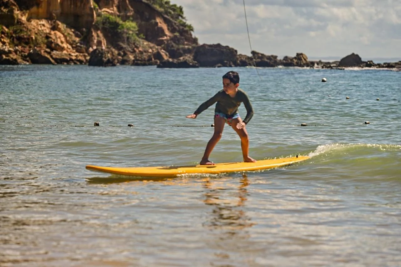 Participante practicando equilibrio en la tabla · Surf School MSP · Primera Playa · Morro de São Paulo, Bahia
